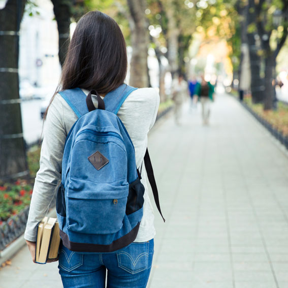 a woman with a backpack walks away from the camera