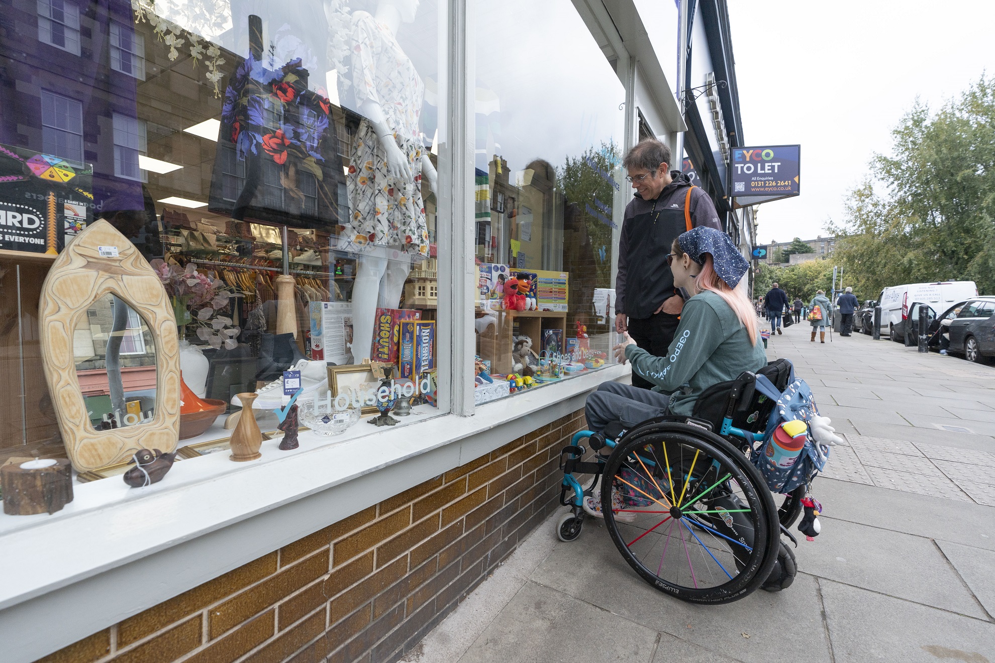 An image of two people looking in a shop window