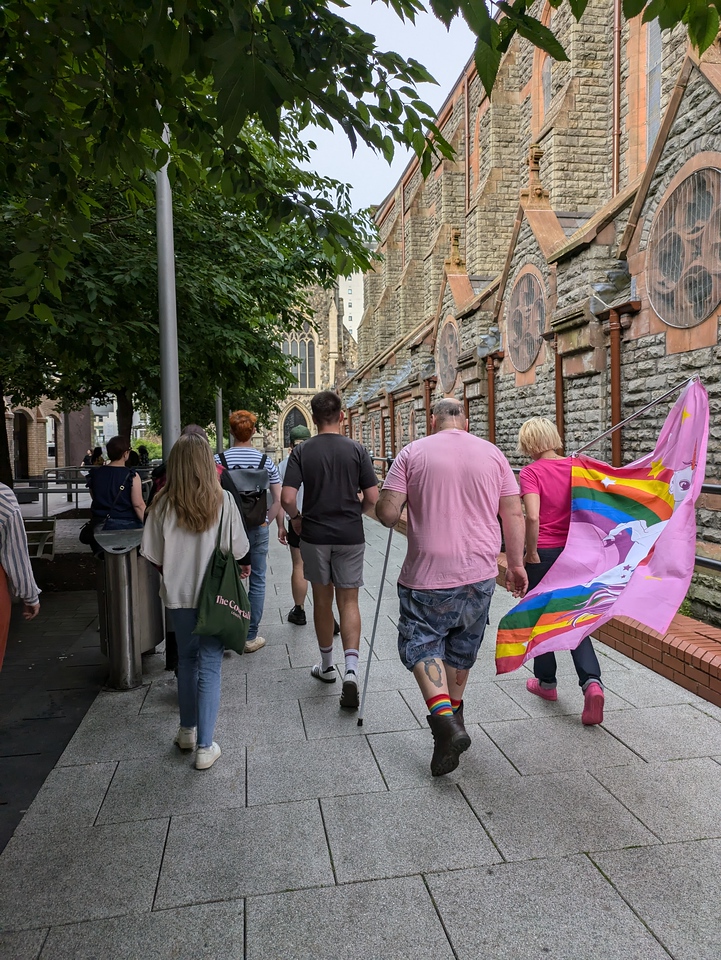 A group of people are walking down a street next to a church