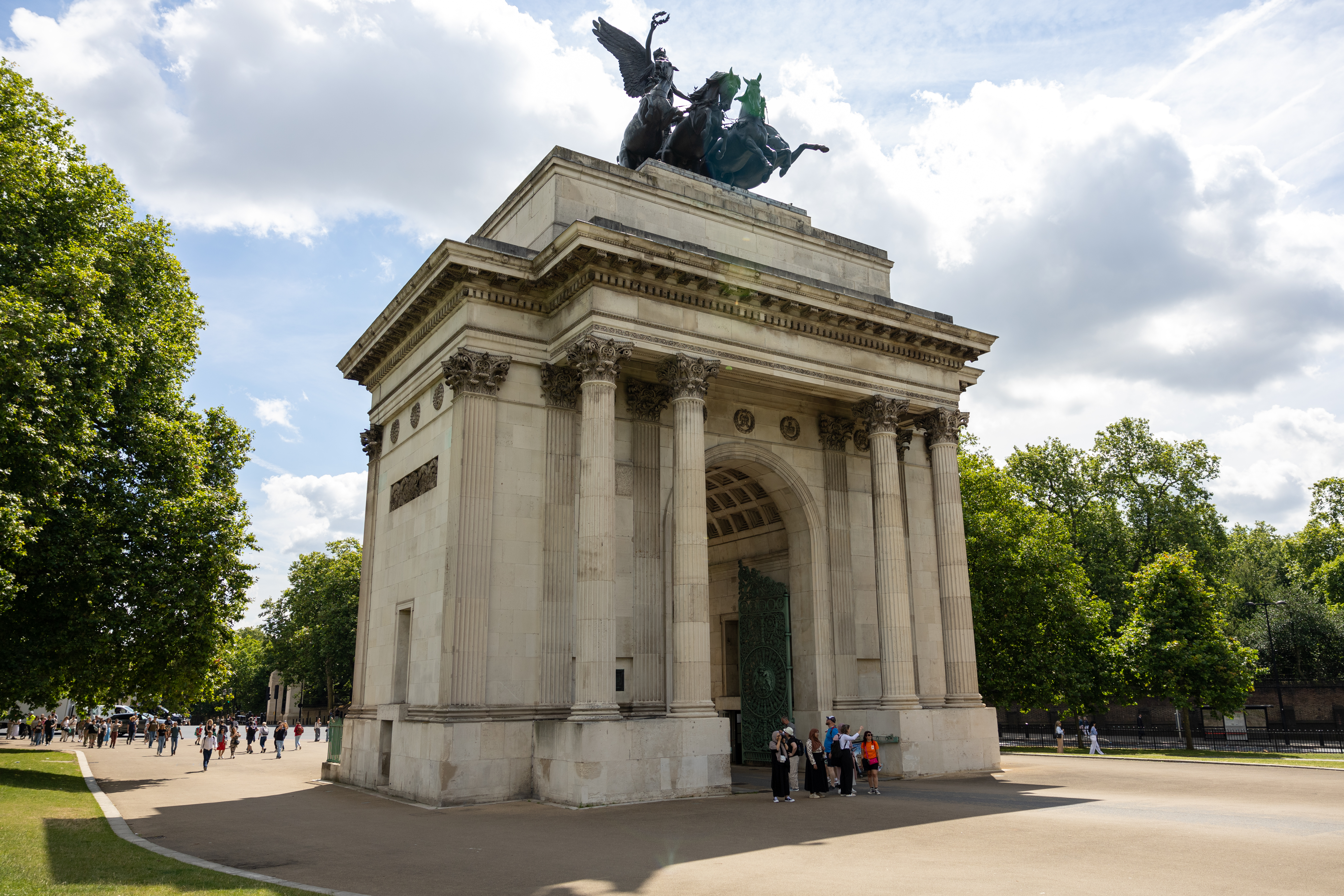 A group of women are standing underneath a WW2 memorial in London