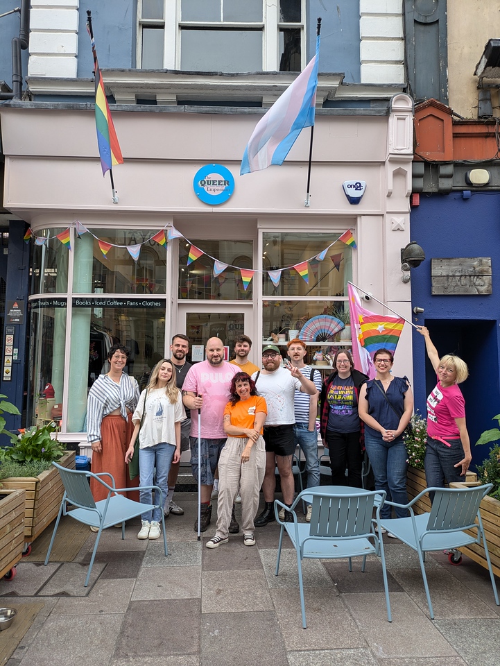 A group of people stand in front of The Queer Emporium